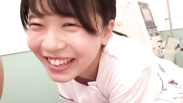 Smiling Japanese teen in white nurse uniform grinning happily close-up