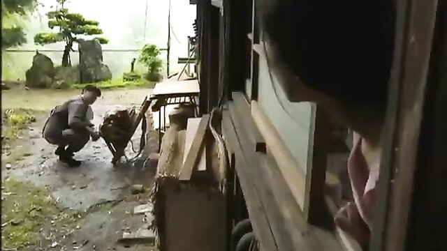 Japanese man kneeling with woman peeking from house in JAV cheating tease