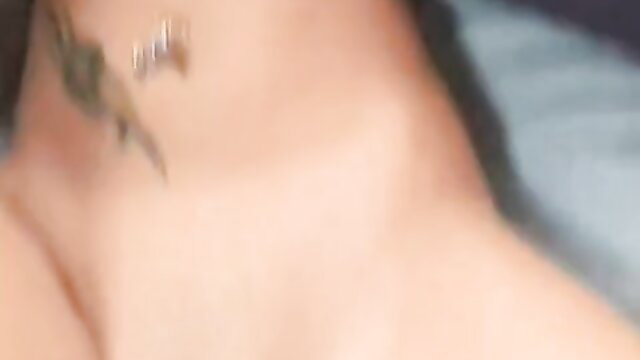 Closeup of woman's neck with sexy tattoo and barbell piercing in adult handjob video