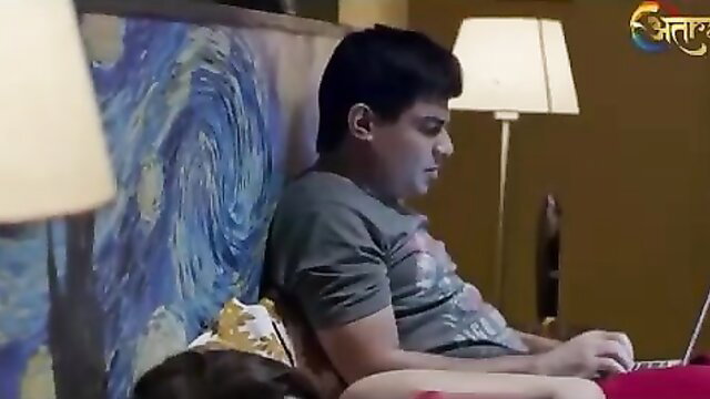 Indian guy on laptop as wife lies nude nearby in bed