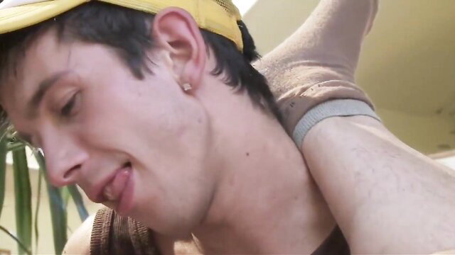 Twink in yellow cap held by hand on socked foot, intense gay fisting scene