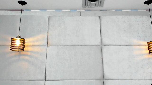 Elegant white tufted wall with hanging lamps in gay bukkake room