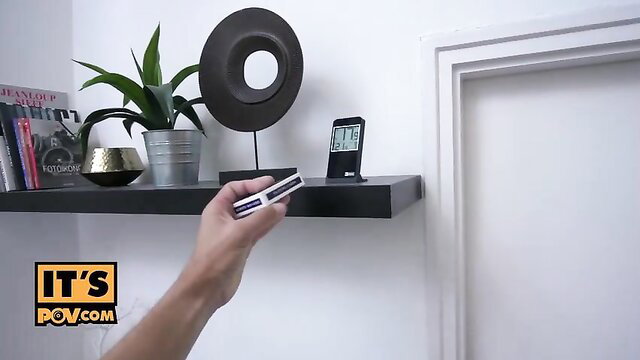Angel Rush holds remote POV on shelf with plants