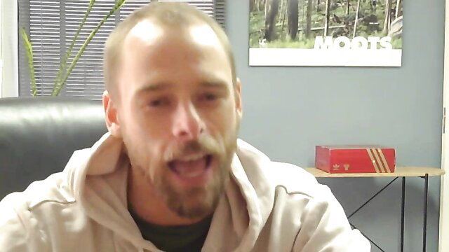 Bald muscular gay man with goatee smiling in hoodie, athletic torso worship