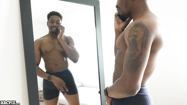 Muscular black man in tight underwear on phone, mirror reflection