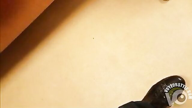 Closeup of woman's gorgeous shiny black high heel and legs in tight skirt