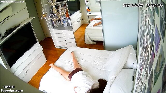 Amateur Asian girl lying topless on bed in shorts, legs spread