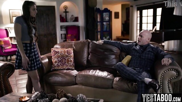 Small teen in plaid skirt stands by bald older stepdaddy on couch