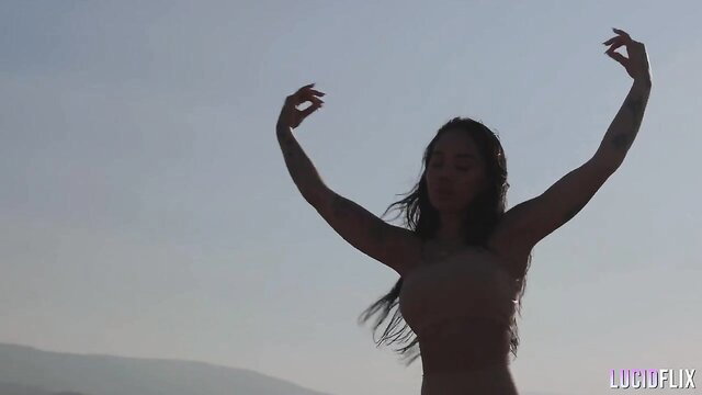 Honey Gold nude silhouette arms raised outdoor beach scene