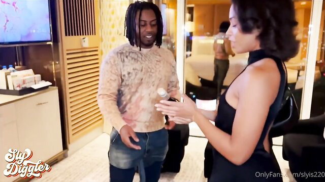 Black dreadlocked guy in sweater flirts with busty black woman in sexy black dress at dinner