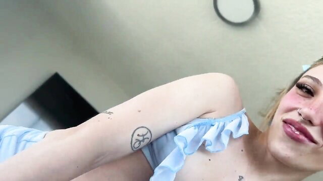 Seductive tattooed girl in slutty blue lingerie tempts with sultry gaze