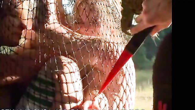 Hot blonde in fishnet bodysuit fucked outdoors with red dildo