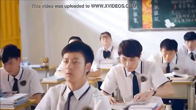 Group of cute Asian schoolboys in uniforms at classroom desks