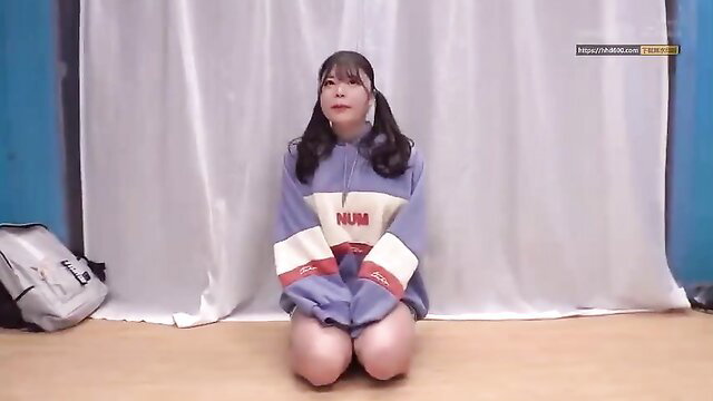 Cute Asian girl with pigtails kneels in baggy NUM hoodie, sexy thighs out