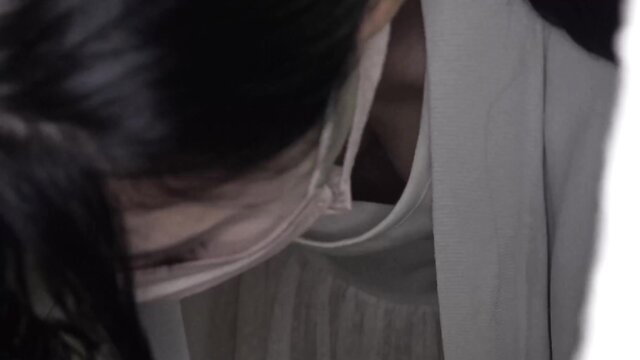 Asian woman in white dress and mask, cleavage tease closeup