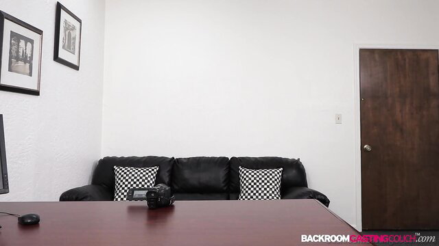 Nina in empty room with black leather couch and camera setup
