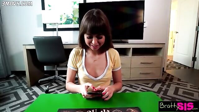 Tai Sis in yellow tank top, smiling at phone in Bratty Sis stepbro scene