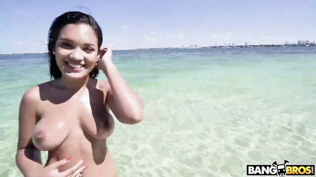 Exotic brunette nude in turquoise ocean, smiling on summer vacation beach