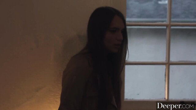 Izzy Lush nude brunette by window in dim light, sensual gaze