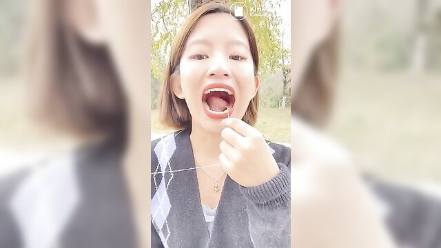 Kat10 Asian model sticks out tongue with toothpick, open mouth tease