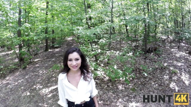 Brunette in white blouse smiles in forest, outdoor POV tease