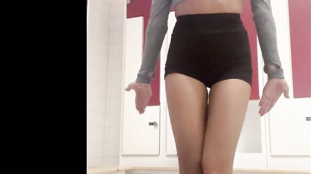 Slim Asian teen in tight shorts and crop top poses seductively