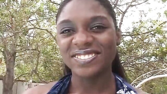 Smiling black beauty in sexy wrap on sunbed, naughty outdoor tease