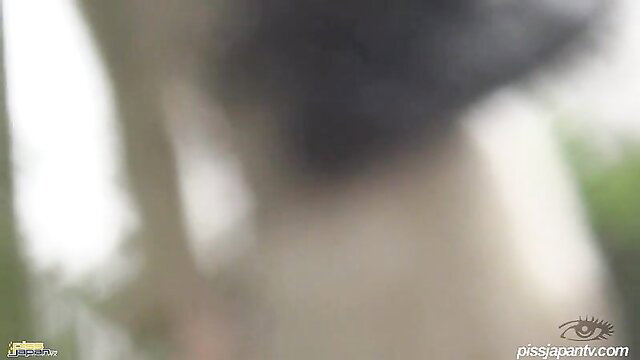 Asian woman squatting outdoors pissing on pavement, wet thighs