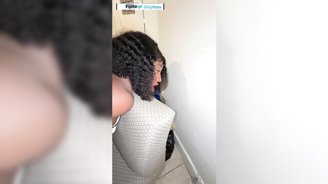 Curvy black woman with big tits leaning over couch in tight top