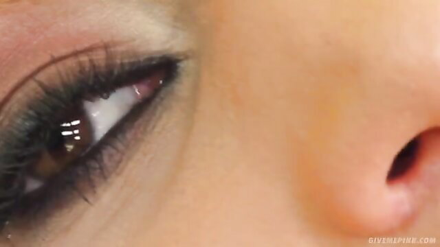 Closeup of blonde model's sultry eye and glossy lips in lingerie