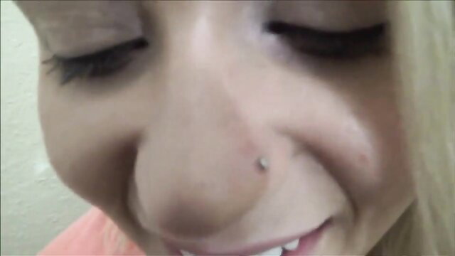 Closeup of gorgeous blonde teen's smiling face with nose piercing