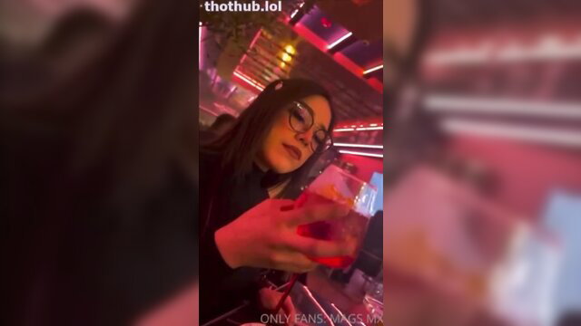 Hot brunette slut Mags mx holds phone in neon club, seductive gaze