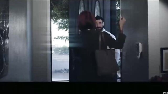 Anna Bell Peaks stands at door in black top and bag with bearded man