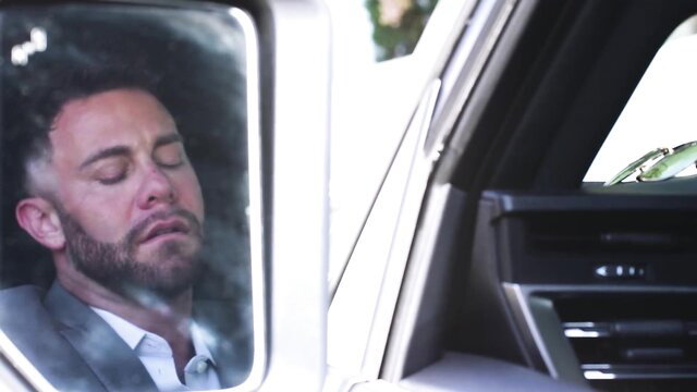 Seth Gamble sleeping in car, suited up closeup