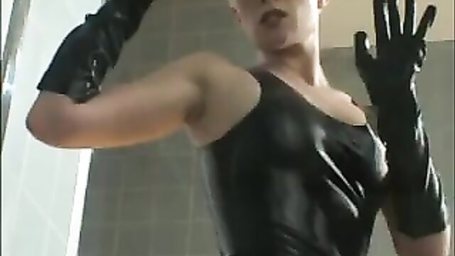 Hot babe in shiny black latex dress and long gloves poses seductively