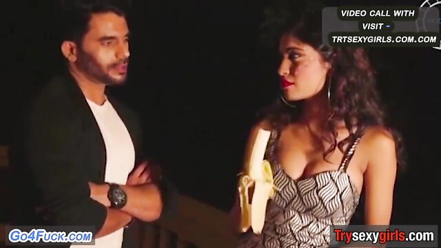 Hot Indian teen seductress in deep cleavage dress holds banana on video call