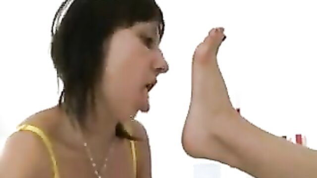 Bob-haired brunette mistress talking to lesbian foot slave's bare foot