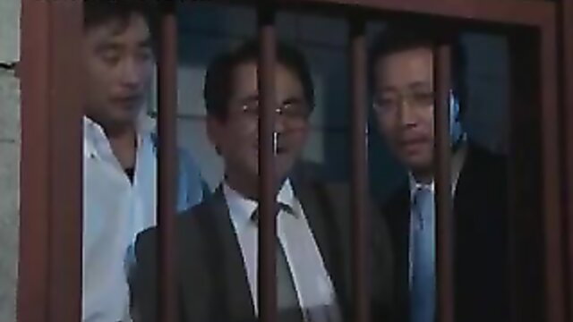 Fragile Asian men in suits behind bars in prison sex slave scene