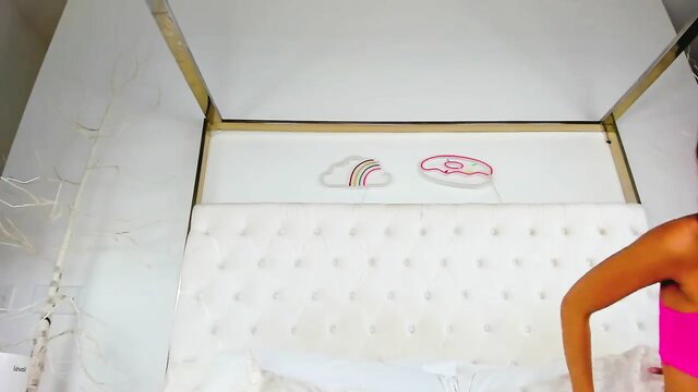 Casey Kisses poses sexy on bed in pink top, hot trans babe