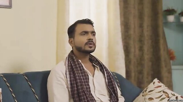 Indian bhabhi in white kurta and scarf sits seductively on sofa