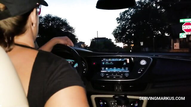 Blonde Uber driver in tank top at stop sign, POV passenger view