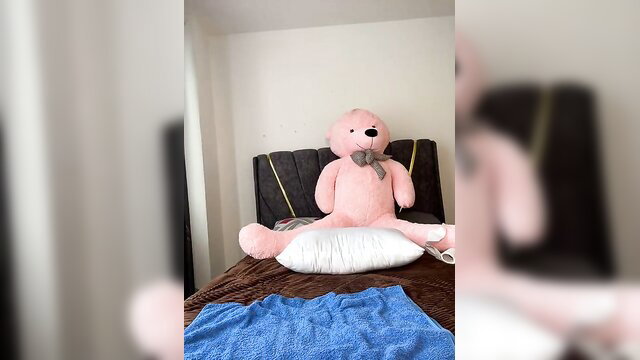 Giant pink teddy bear on bed in cozy bedroom