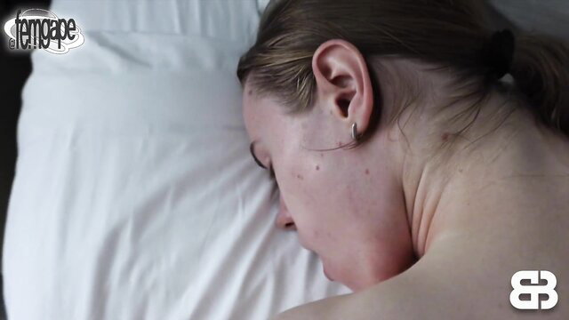 Blonde woman sleeping nude on pillow, bare back and shoulder exposed