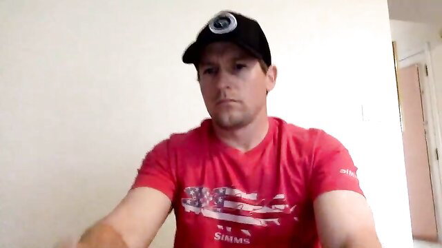 Daddy gay tickling video thumbnail: muscular white guy in red Simms shirt and black cap