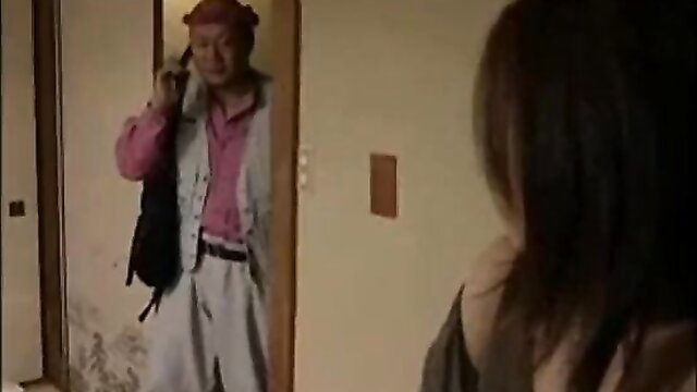 Japanese man in pink shirt and white pants talks on phone at door in JAV