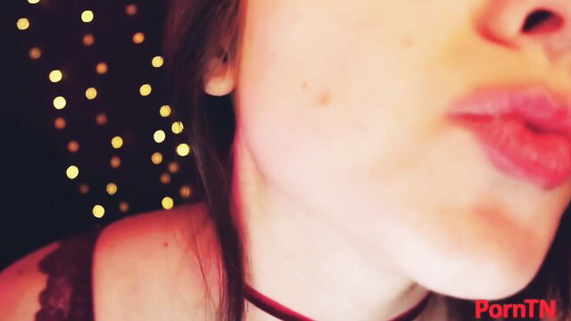 Closeup of brunette beauty puckering glossy lips, seductive gaze