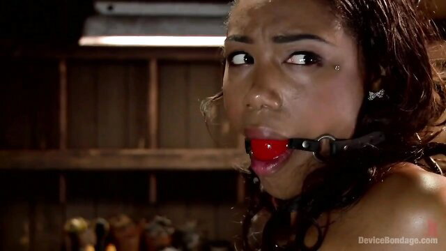 Ebony babe gagged with red ball gag in bondage chains, intense expression