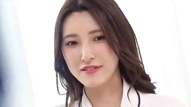 Beautiful Asian woman with long brown hair in tight white blouse closeup