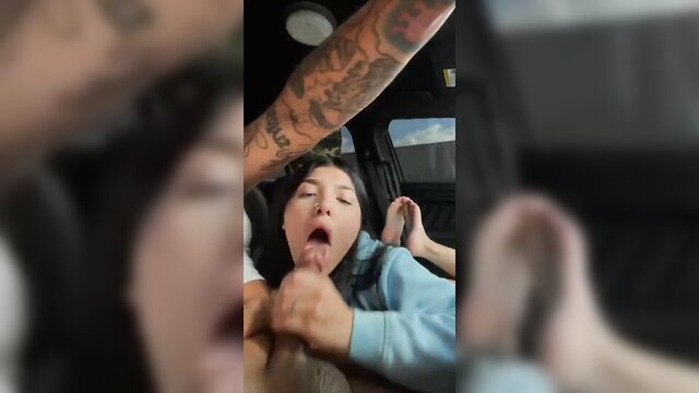 Tattooed guy gets car blowjob from brunette Asian girl with feet up