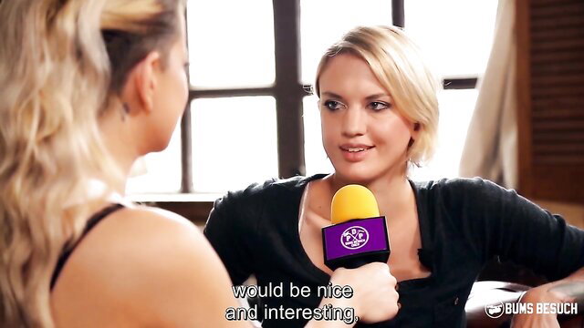 Sina Longleg blonde beauty interviewed with mic in black top